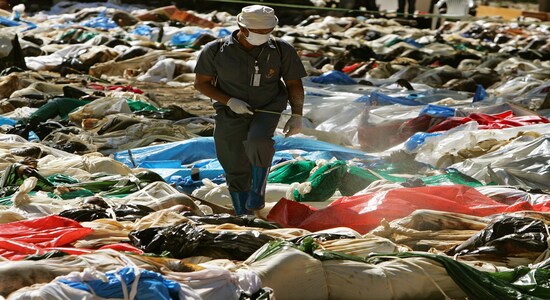 SENSITIVE MATERIAL. THIS IMAGE MAY OFFEND OR DISTURB FILE PHOTO: A Thai health official sprays hundreds of decaying corpses with effective microorganisms (EM) at a temple in Ban Muan, north of the Thai resort island of Phuket, December 30, 2004 following the deadly tsunami. REUTERS/Adrees Latif