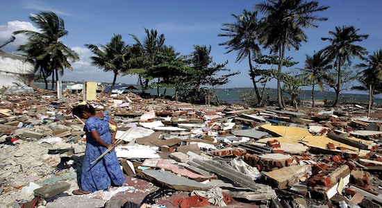 FILE PHOTO: A woman wanders around the rubble in the commercial center of the town of Galle, southern Sri Lanka, on January 30, 2005 after it was flattened by the December 26 tsunami. REUTERS/Desmond Boylan