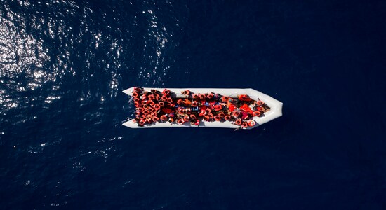 FILE - In this Sunday, May 6, 2018 file photo, refugees and migrants wait to be rescued by members of the Spanish NGO Proactiva Open Arms, after leaving Libya trying to reach European soil aboard an overcrowded rubber boat, north of Libyan coast. The United Nations is urging governments, businesses and others to “reboot&quot; the world's response to refugees as the number of people fleeing their homes rises along with hostility to migrants. The U.N. and Switzerland are hosting the first Global Refugee Forum in Geneva Tuesday and Wednesday. (AP Photo/Felipe Dana, file)