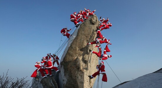 In this Sunday, Dec. 22, 2019, file photo, mountain climbers in Santa Claus outfits pose during an event to hope for safe climbing and to promote Christmas charity on the Buckhan mountain in Seoul, South Korea. (AP Photo/Ahn Young-joon, File)