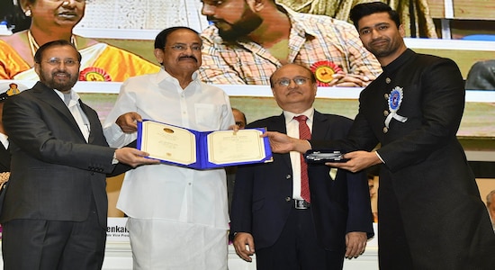 Vice President Venkaiah Naidu, second left, presents the national film award to Bollywood actor Vicky Kaushal , right, who shared the best actor award with actor Ayushmann Khurrana during the national film awards ceremony in New Delhi, India, Monday, Dec.23, 2019. Information and Broadcasting Minister Prakash Javdekar is on left. (AP Photo)