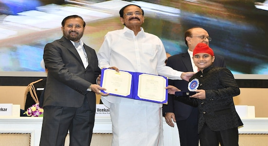 Vice President Venkaiah Naidu, second left, presents the national film award for best child artist to Sameep Ranaut, right, during the national film awards ceremony in New Delhi, India, Monday, Dec.23, 2019. Information and Broadcasting Minister Prakash Javdekar is on left. (AP Photo)