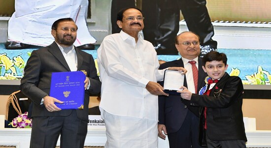 Vice President Venkaiah Naidu, second left, presents the national film award for best child artist to Talha Arshad Reshi, right, during the national film awards ceremony in New Delhi, India, Monday, Dec.23, 2019. Information and Broadcasting Minister Prakash Javdekar is on left. (AP Photo)