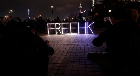 In this Monday, Dec. 23, 2019, file photo, people take photos a sign &quot;Free HK&quot; during a rally in Hong Kong. Protesters attended at a rally to protest against Hong Kong Police's latest action to freeze money raised by a fundraising platform which was used to support the city's anti-government protests. (AP Photo/Lee Jin-man, File)