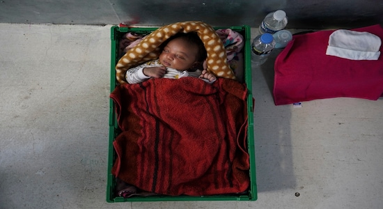 In this Sept. 18, 2019 photo, newborn baby Ange sleeps in a makeshift crib aboard the Ocean Viking humanitarian ship as it sails in the Mediterranean Sea. His mother, Prudence Aimee, gave birth to her third son Sept. 13, just three days before boarding an overcrowded wooden boat in the hope of getting her children out of war-torn Libya. Her husband was not able to join them and stayed behind. (AP Photo/Renata Brito)