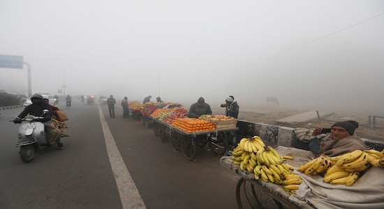 Fruit sellers wait for customer amidst dense fog early morning in New Delhi, India, Monday, Dec. 30, 2019. Delhi, which is witnessing the longest spell of cold weather in the last 22 years, woke up to a blanket of dense fog engulfing most parts of the national capital on Monday morning, disrupting rail, road and air traffic adversely. (AP Photo/Manish Swarup)
