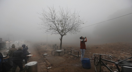 A man drinks water after eating from a roadside snack vendor amidst dense fog early morning in New Delhi, India, Monday, Dec. 30, 2019. Delhi, which is witnessing the longest spell of cold weather in the last 22 years, woke up to a blanket of dense fog engulfing most parts of the national capital on Monday morning, disrupting rail, road and air traffic adversely. (AP Photo/Manish Swarup)