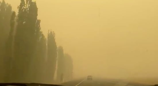A vehicle is engulfed in yellowish smoke as it travels along a highway during bushfires near Cooma, New South Wales, Australia January 1, 2020 in this picture obtained from social media. Picture taken January 1, 2020. Mandatory credit JODIE BRADBY CANBERRA AUSTRALIA/via REUTERS
