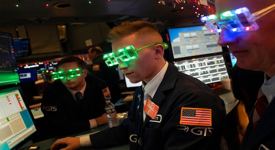 Stock traders wear New Year's 2020 party glasses at New York Stock Exchange, Tuesday, Dec. 31, 2019. Stocks slipped globally in quiet New Year's Eve trading Tuesday with many markets closed. Wall Street could close 2019 with back-to-back daily losses in a year that the U.S. posted the largest market gains since 2013. (AP Photo/Mark Lennihan)