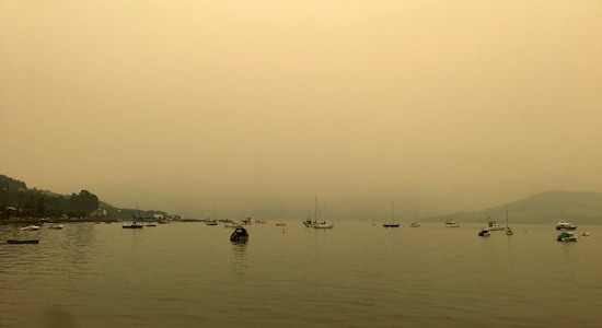 A yellow light illuminates the sky as the sun sets over Akaroa Harbor as smoke from the Australian wildfires arrives on the east coast of the South Island, New Zealand, Wednesday, Jan. 1, 2020. Australia deployed military ships and aircraft to help communities ravaged by apocalyptic wildfires that destroyed homes and sent thousands of residents and holidaymakers fleeing to the shoreline. (Eric Young via AP)