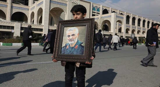 A boy carries a portrait of Iranian Revolutionary Guard Gen. Qassem Soleimani, who was killed in a U.S. airstrike in Iraq, prior to the Friday prayers in Tehran, Iran, Friday Jan. 3, 2020. Iran has vowed &quot;harsh retaliation&quot; for the U.S. airstrike near Baghdad's airport that killed Tehran's top general and the architect of its interventions across the Middle East, as tensions soared in the wake of the targeted killing. (AP Photo/Vahid Salemi)