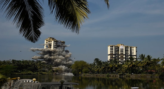 The first tower of water-front residential apartment Alpha Serene implodes moments before the second tower, on right, is blasted using controlled implosion in Kochi, India, Saturday, Jan. 11. 2020. Authorities in southern Kerala state on Saturday razed down two high-rise luxury apartments using controlled implosion in one of the largest demolition drives in India involving residential complexes for violating environmental norms. (AP Photo/R S Iyer)