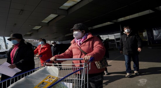 Customers wearing face masks leave a supermarket, as the country is hit by an outbreak of the novel coronavirus, in Beijing, China February 15, 2020. REUTERS/Stringer