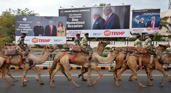 Border Security Force (BSF) soldiers ride their camels past hoardings with the images of Prime Minister Narendra Modi, US President Donald Trump and first lady Melania Trump, as they take part in a rehearsal for a road show ahead of Trump's visit, in Ahmedabad. (REUTERS/Amit Dave)