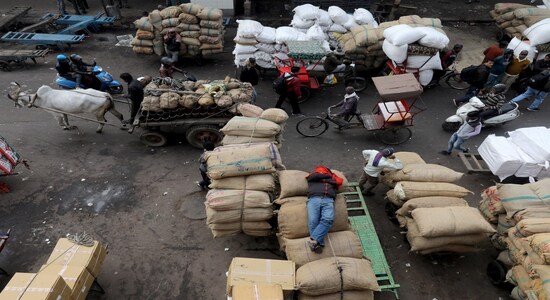 A labourer sleeps on sacks as traffic moves past him in a wholesale market in the old quarters of Delhi A labourer sleeps on sacks as traffic moves past him in a wholesale market in the old quarters of Delhi