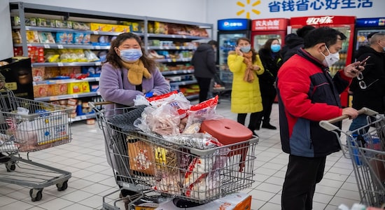 FILE - In this Jan. 22, file 2020 photo, shoppers wear face masks as they line up at a grocery store in Wuhan in central China's Hubei Province. Arek and Jenina Rataj were starting a new life in the Chinese industrial center of Wuhan when a viral outbreak spread across the city of 11 million. While they were relatively safe sheltering at home, Arek felt compelled to go out and document the outbreak of the new type of coronavirus. Among his subjects: the construction of a new hospital built in a handful of days; biosecurity check points; and empty streets. (AP Photo/Arek Rataj, File) FILE - In this Jan. 22, file 2020 photo, shoppers wear face masks as they line up at a grocery store in Wuhan in central China's Hubei Province. Arek and Jenina Rataj were starting a new life in the Chinese industrial center of Wuhan when a viral outbreak spread across the city of 11 million. While they were relatively safe sheltering at home, Arek felt compelled to go out and document the outbreak of the new type of coronavirus. Among his subjects: the construction of a new hospital built in a handful of days; biosecurity check points; and empty streets. (AP Photo/Arek Rataj, File)