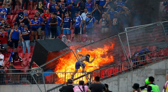 A small group of anti-government protesters set a section of the stadium on fire during the Copa Libertadores soccer game between Universidad de Chile and Brazil's SC Internacional, in Santiago, Chile, Tuesday, Feb. 4, 2020. Chile has been roiled by continuing street protests since Oct. 18, when a student protest over a modest increase in subway fares turned into a much larger and broader movement with a long list of demands that largely focus on inequality. (AP Photo/Luis Hidalgo)