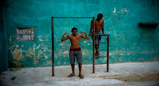 A young man strikes a pose showing off his muscles, framed by a pull up bar in Havana, Cuba, Wednesday, Feb. 5, 2020. (AP Photo/Ramon Espinosa) A young man strikes a pose showing off his muscles, framed by a pull up bar in Havana, Cuba, Wednesday, Feb. 5, 2020. (AP Photo/Ramon Espinosa)