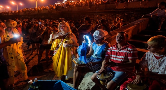 People participate in a ritual for the African sea goddess Yemanja, at a beach in Montevideo, Uruguay, Sunday, Feb. 2, 2020. Thousands of worshippers come to the beach on Yemanja's feast day, bearing candles, flowers, perfumes and fruit to show their gratitude for her blessings. The celebration coincides with the Roman Catholic Feb. 2 feast day of the Virgin of Candelaria. (AP Photo/Matilde Campodonico)