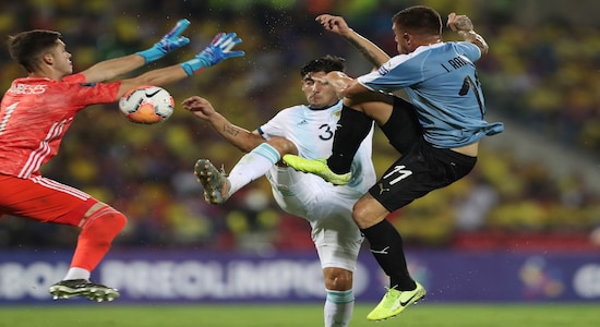 Argentina's goalkeeper Facundo Cambeses, left, and Claudio Bravo, center, battle for the ball with Uruguay's Juan Ramirez during a South America Olympic qualifying U23 soccer match at the Alfonso Lopez stadium in Bucaramanga, Colombia, Monday, Feb. 3, 2020. (AP Photo/Fernando Vergara)