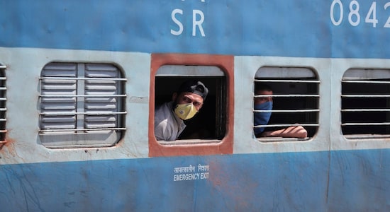 FILE - In this Monday, March 23, 2020, file photo, passengers wearing masks look out from a train in Jammu, India. India's colossal passenger railway system has come to a halt as officials take emergency measures to keep the coronavirus pandemic from spreading in the country of 1.3 billion. The lifeline was cut Sunday, leaving hundreds of people stranded at railway stations, hoping to be carried onward by buses or taxis that appeared unlikely to arrive. The railway system is often described as India's lifeline, transporting 23 million people across the vast subcontinent each day, some 8.4 billion passengers each year. (AP Photo/Channi Anand, File)
