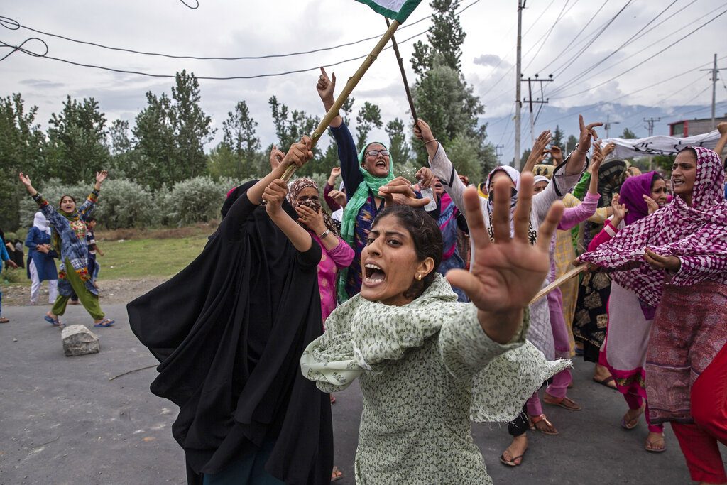 Women shout slogans as policemen fire teargas and live ammunition in the air to stop a protest march in Srinagar, Aug. 9, 2019. (AP Photo/Dar Yasin)