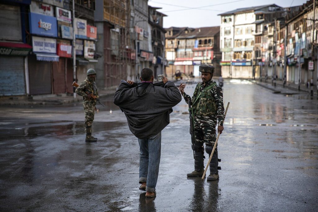An Indian paramilitary soldier orders a Kashmiri to open his jacket before frisking him during curfew in Srinagar, Aug. 8, 2019. (AP Photo/Dar Yasin)