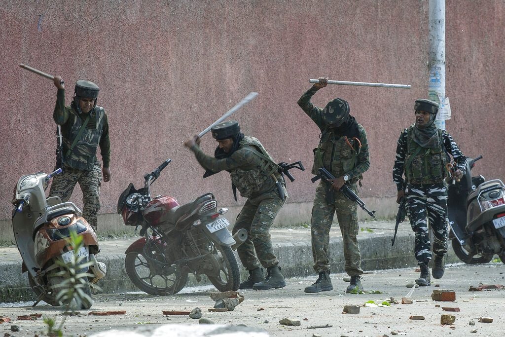 Indian paramilitary soldiers break motorbikes parked outside a college as they clash with students protesting against the alleged rape of a 3-year-old girl in Srinagar, May 14, 2019. (AP Photo/Dar Yasin)