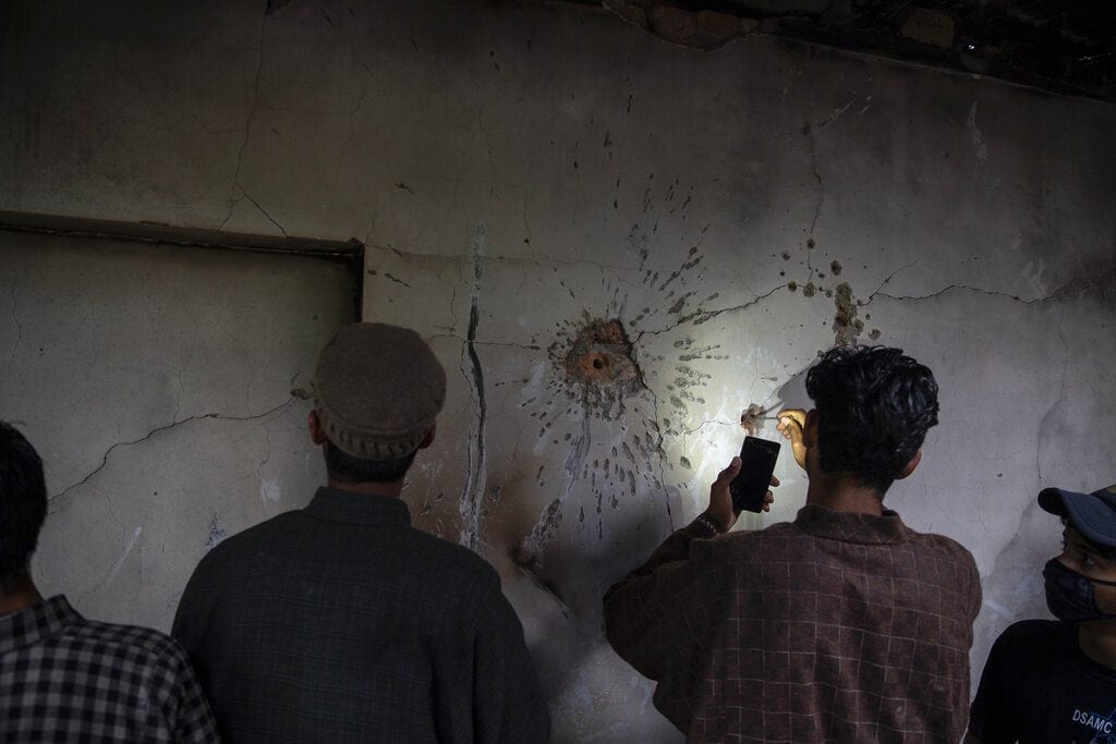 A Kashmiri boy tries to take out a bullet from the wall of a damaged house after a gunbattle in Tral, south of Srinagar, May 24, 2019. (AP Photo/Dar Yasin)