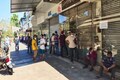 People stand in long queues for hours ahead of liquor stores