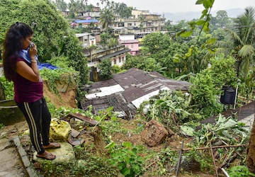 Guwahati: A woman looks toward the damaged boundary wall after a landslide owing to rains at Hengrabari, in Guwahati, Wednesday, June 15, 2022. 