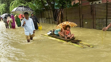 lood-affected people use a banana raft to shift to safe place, in Bajali district of Assam. (Image: PTI)