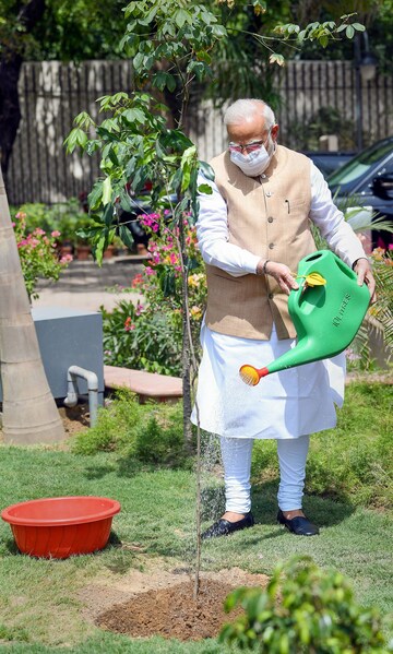 me Minister Narendra Modi gives water to a sapling during the inauguration of ‘Vanijya Bhawan’ and launch of the 'NIRYAT' Portal, in New Delhi.