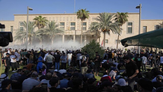 Iraqi security forces fire tear gas on the followers of Shiite cleric Muqtada al-Sadr inside the government Palace, Baghdad, Iraq, Monday, Aug. 29, 2022.