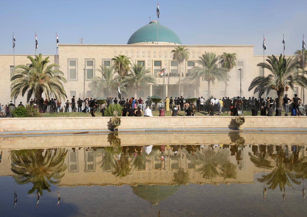 Iraqi security forces fire tear gas on the followers of Shiite cleric Muqtada al-Sadr inside the government Palace, Baghdad, Iraq, Monday, Aug. 29, 2022.