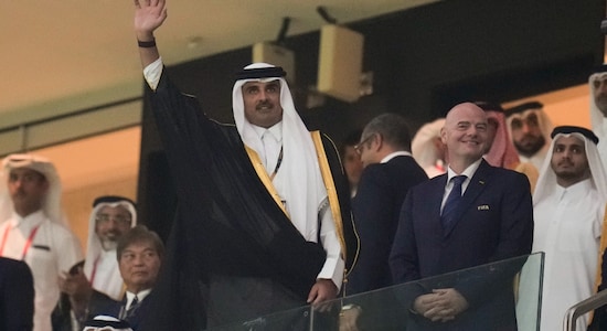 Sheikh Tamim bin Hamad Al Thani waves next to FIFA President Gianni Infantino prior to the opening World Cup opening match