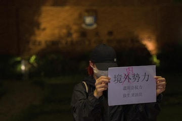 A protester holds up a paper which reads "Not foreign forces but internal forcers" and "Abuse of Government power plunge the people into misery and suffering" during a gathering at the University of Hong Kong in Hong Kong, Tuesday. (AP)