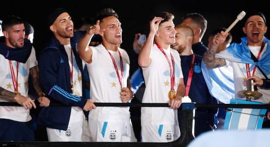 Argentina's Lautaro Martinez and Julian Alvarez along with their teammates at the top of the bus as the team commences its victory parade through Buenos Aires. (Image: Reuters)