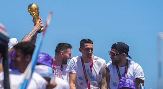 Captain Lionel Messi, left, chats with teammates Angel Di Maria, center, and Nicolas Otamendi on the top of a bus during a homecoming parade for the Argentine soccer team