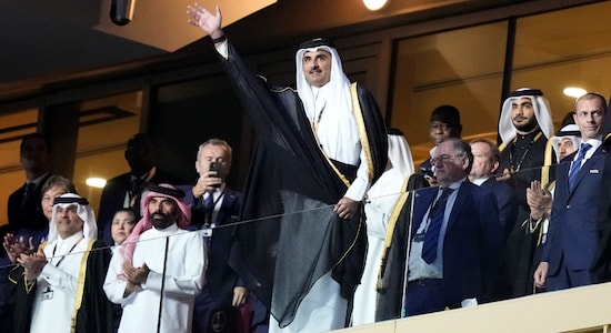 The Emir of Qatar Sheikh Tamim bin Hamad Al Thani waves as he arrives on the tribune ahead of the World Cup final soccer match between Argentina and France at the Lusail Stadium in Lusail, Qatar